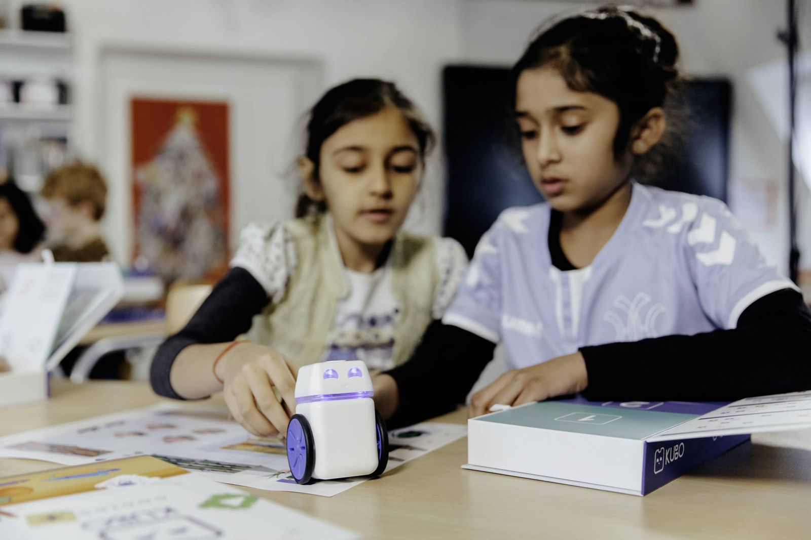 Two students programming KUBO with TagTiles at a classroom table